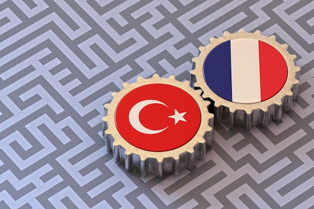 Bandiere della Turchia e della Francia su un ingranaggio isolato su sfondo labirinto
