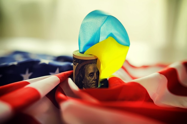 Bandiere ucraine e americane un pacchetto di dollari americani Concetto di aiuto e lendlease