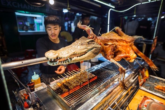 Bangkok, Thailandia, 6 dicembre 2019: Un venditore ambulante che vende spiedini di coccodrillo su Khao San Street a Bangkok.