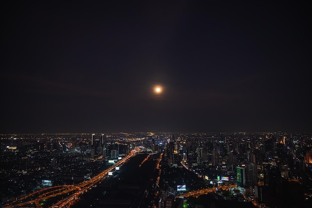 Bangkokthailand16042022Vista del paesaggio urbano di Bangkok con la bella luna piena dalla cima dell'edificio nella città di Bangkok