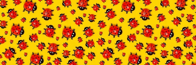 Banner con motivo di coccinelle su sfondo giallo come sfondo o trama Carta da parati estiva luminosa Vista dall'alto Posa piatta