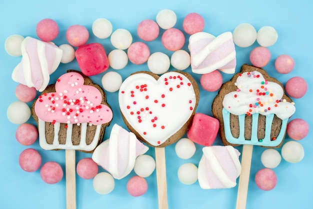 Banner cookie su un bastone e caramelle su sfondo blu Deliziosi dolci vista dall'alto e spazio per la copia