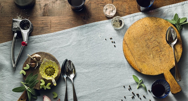 Banner di classico risotto italiano con funghi su un tavolo di legno con una tovaglia di lino blu bottiglia di vino rosso e bicchieri top shots