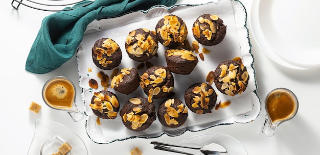 Banner di muffin vegani con banana e chips di mandorle con espresso su vassoio senza glutine e paleo raffinato senza zucchero