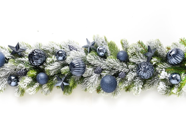 Banner di Natale con palline blu e stelle in fila su rami sempreverdi innevati