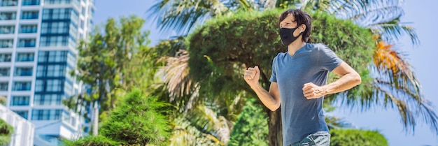 Banner lungo formato uomo corridore che indossa maschera medica che corre in città sullo sfondo del