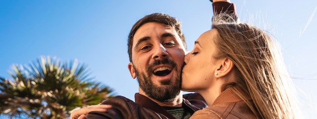 Banner orizzontale o intestazione con giovane coppia hipster che si diverte a fare un selfie ritratto contro un bellissimo panorama al tramonto Fidanzato e fidanzata innamorati che sorridono insieme alla telecamera