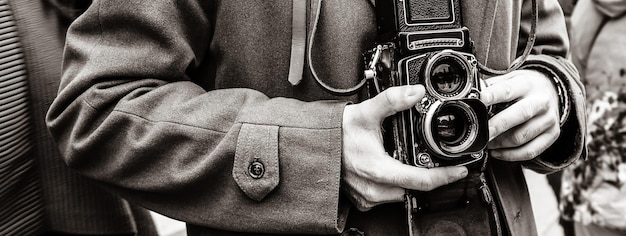 Banner orizzontale o intestazione con ragazzo Hipster con la macchina fotografica vintage che fotografa persone in città Fotoreporter con una famosa macchina fotografica retrò che scatta foto tra la folla durante la dimostrazione di strada