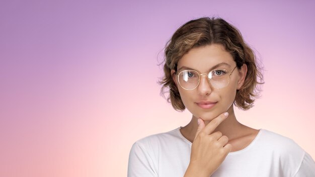 Banner ritratto promozionale in studio di una ragazza intelligente e riflessiva con gli occhiali