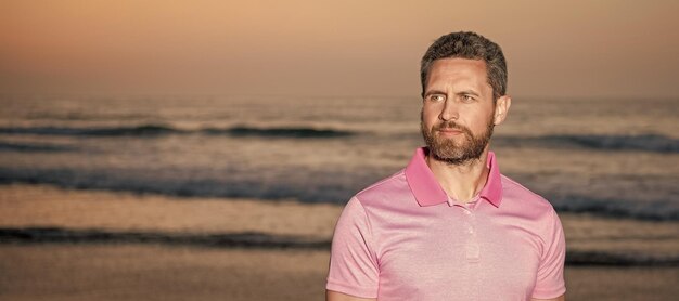 Banner ritratto viso uomo con spazio copia uomo carismatico con la barba al tramonto sul mare ragazzo con la barba lunga sulla spiaggia del mattino