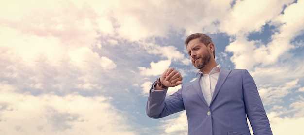 Banner ritratto viso uomo con spazio per la copia Uomo d'affari in tuta blu cielo sfondo uomo in tuta blu professionale e orologio da polso puntualità manager tempo di controllo