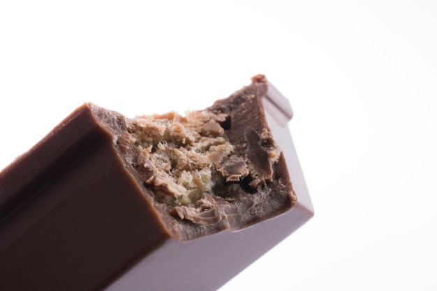 Bar di cioccolato morso su uno sfondo bianco