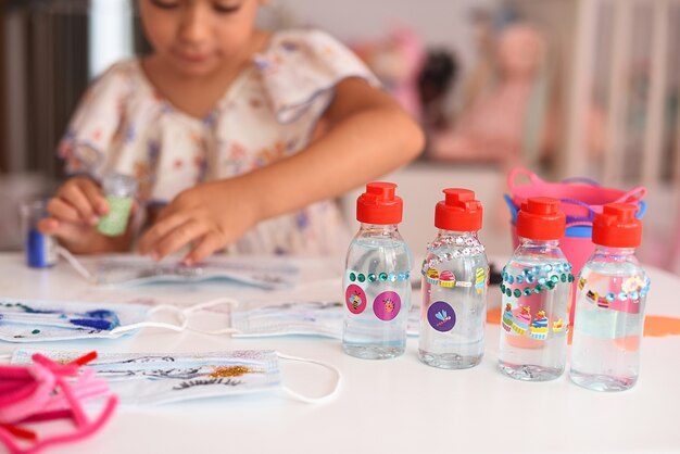 Barattoli di gel disinfettante per bambini con una ragazza sullo sfondo. Messa a fuoco selettiva