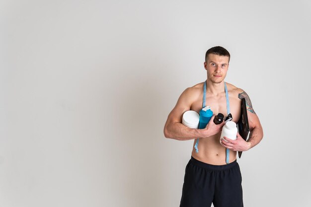 Barattoli di proteine fitness bianco su sfondo bianco bodybuilder in polvere forte corpo alto schiena persona