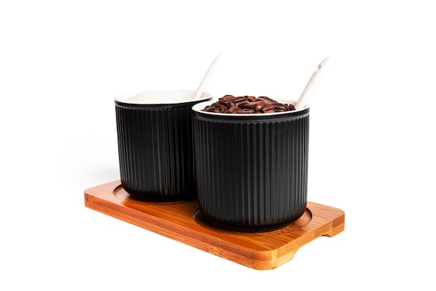 Barattoli di spezie nere con zucchero e chicchi di caffè isolati su sfondo bianco. Zuccheriera. Foto di alta qualità