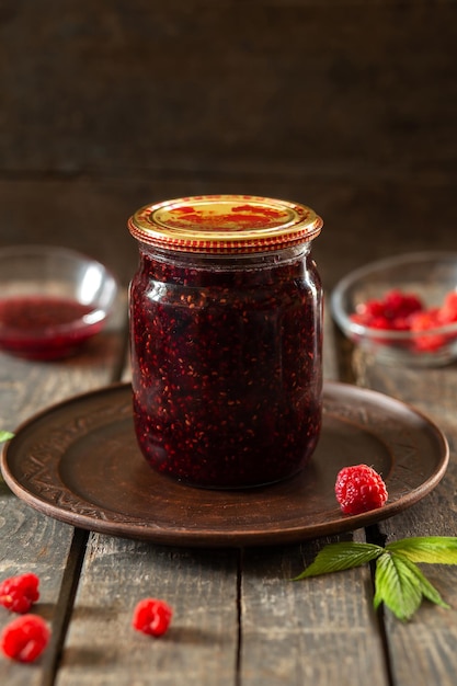 Barattolo chiuso di marmellata di lamponi su tavole di legno Conservazione degli alimenti per la cottura