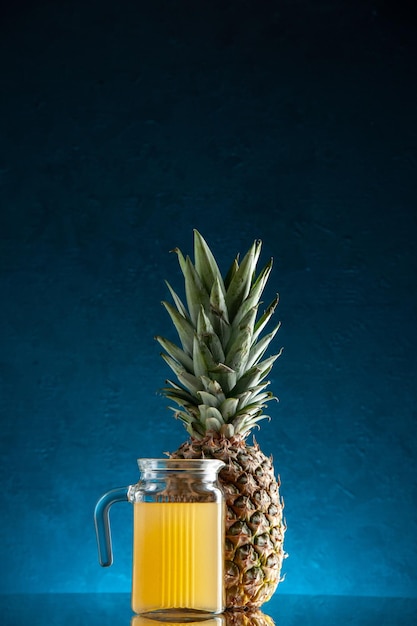 barattolo da cocktail in vetro vista frontale con succo e ombrellone ananas su sfondo blu scuro