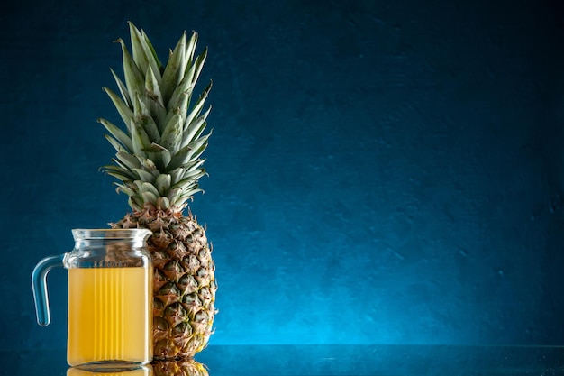 barattolo da cocktail in vetro vista frontale con succo e ombrellone cocktail ananas su sfondo blu scuro spazio libero