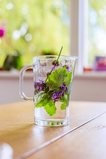 Barattolo di acqua fredda e rinfrescante in estate Gustosa limonata con erbe multicolori