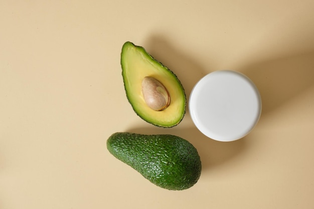 Barattolo di cosmetici mockup bianco e avocado su sfondo beige