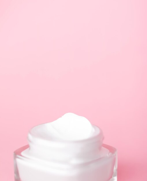 Barattolo di crema idratante per il viso su sfondo rosa lozione idratante per la cura della pelle e emulsione lifting cosmetici antietà per il marchio di cura della pelle di bellezza di lusso