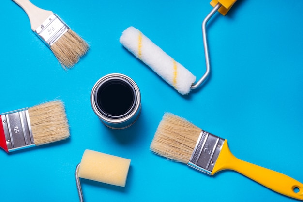 Barattolo di latta con vernice e molti pennelli decoratori diversi