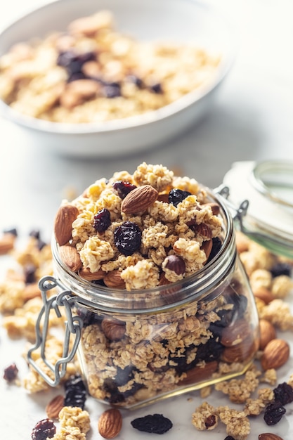 Barattolo di muesli con noci, mandorle uva e frutta secca - primo piano.