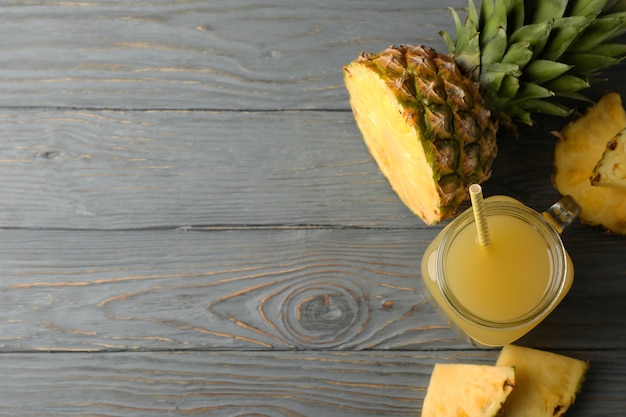 Barattolo di succo di ananas e fette su sfondo di legno