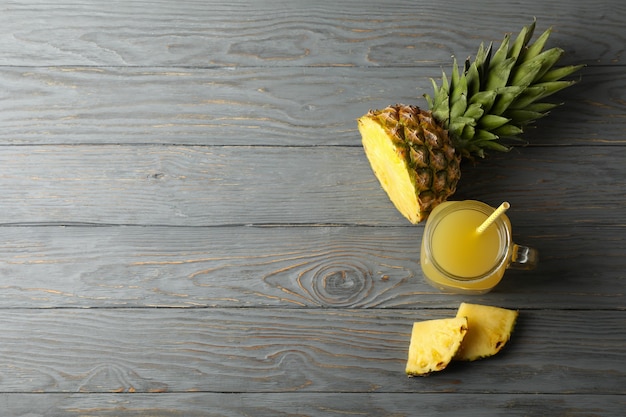 Barattolo di succo di ananas e fette su sfondo di legno