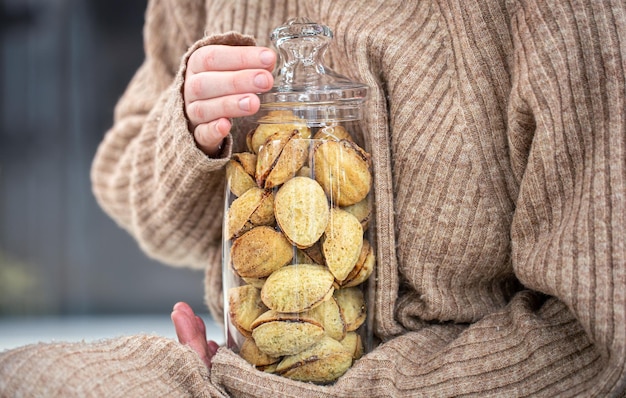 Barattolo di vetro con biscotti noci con latte condensato in mani femminili