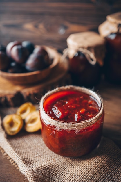 Barattolo di vetro con deliziosa marmellata di prugne fatta in casa sul tavolo