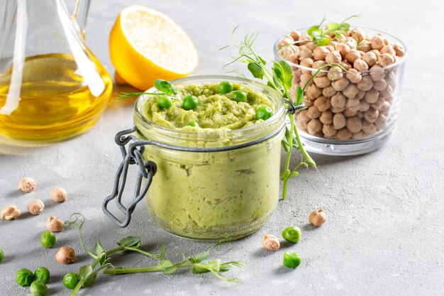 Barattolo di vetro di hummus verde, deliziosa crema di ceci e piselli. Spuntino vegano, vegetariano. Copia spazio