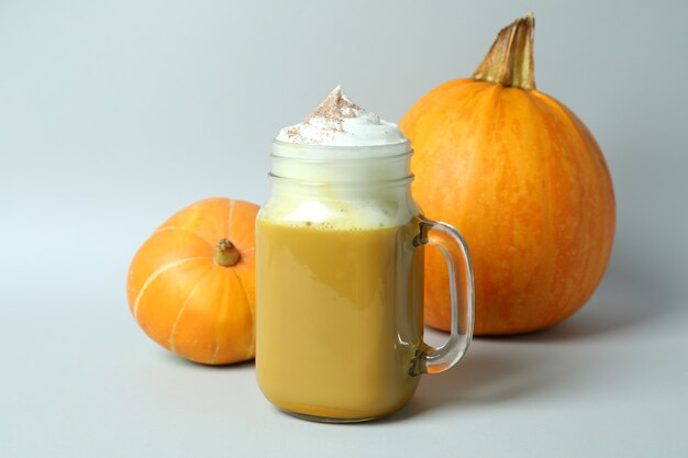 Barattolo di vetro di latte di zucca e ingredienti su sfondo grigio chiaro