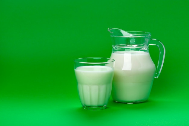 Barattolo e bicchiere di latte su fondo verde