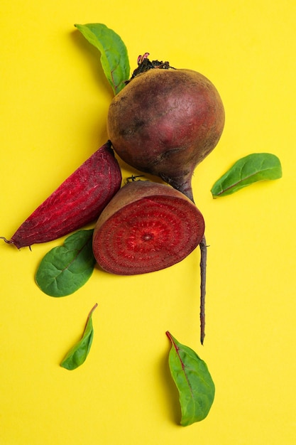 Barbabietola rossa matura con foglie su sfondo giallo