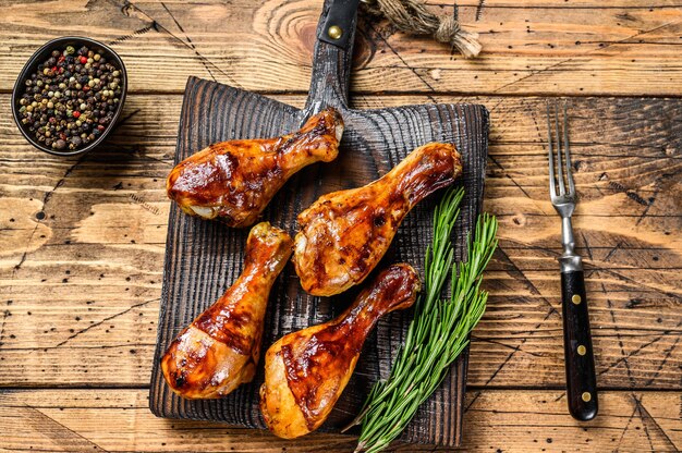 Barbecue bacchette di pollo arrosto su un tagliere di legno