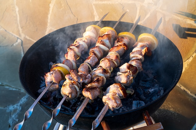 Barbecue caldo della carne di maiale che cucina sulla griglia con le spezie, all'aperto.