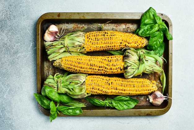 Barbecue mais alla griglia con spezie e salse su uno sfondo di pietra nera cibo biologico vista superiore