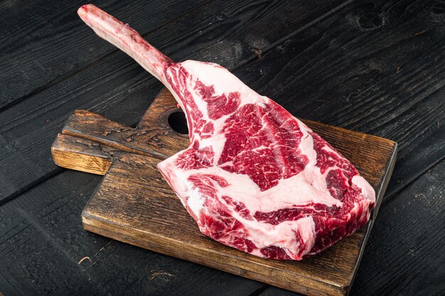 Barbecue Tomahawk marmorizzato Bistecca di manzo, su tavolo in legno nero