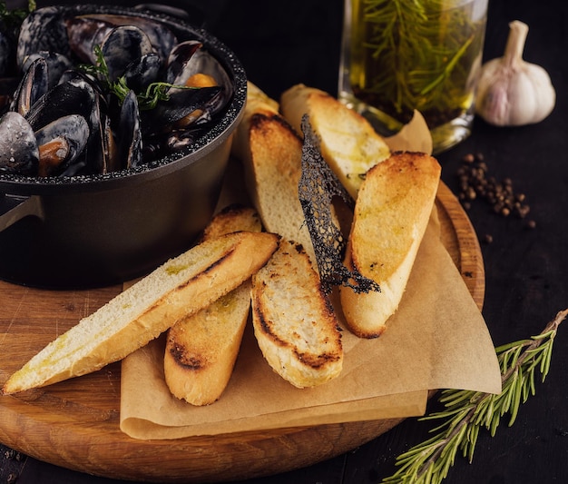 Barbecue tradizionale italiano di cozze blu in salsa di vino con baguette di pane