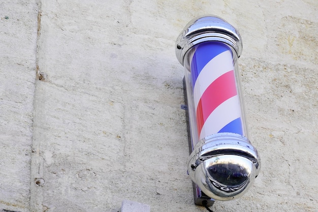 Barber light round tricolore pole spirale shop sign in parrucchiere vintage sulla parete con colori bianco rosso blu