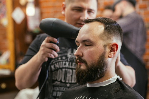 Barbiere, un uomo con la barba tagliata da parrucchiere.