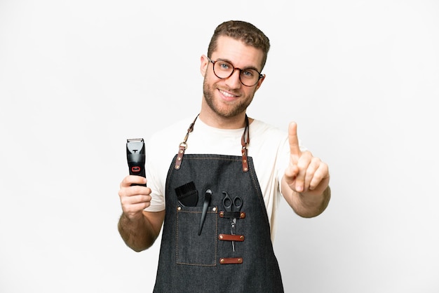 Barbiere uomo in un grembiule su sfondo bianco isolato mostrando e alzando un dito