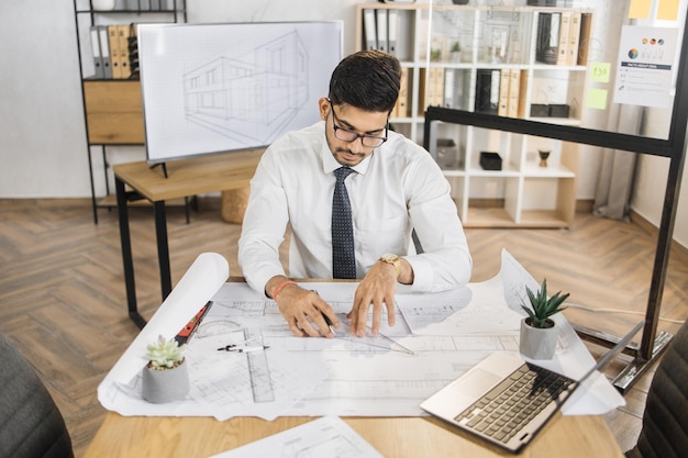 Barbuto uomo musulmano attraente che controlla il processo di lavoro