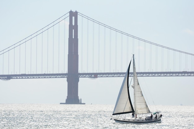 Barca a vela che attraversa la baia di San Francisco con il Golden Gate Bridge sullo sfondo