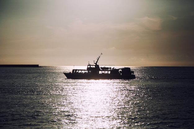 Barca a vela in mare aperto al tramonto