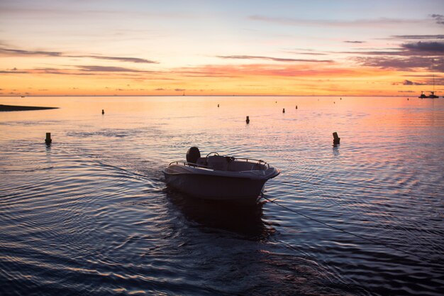 Barca a vela sull'oceano al tramonto.