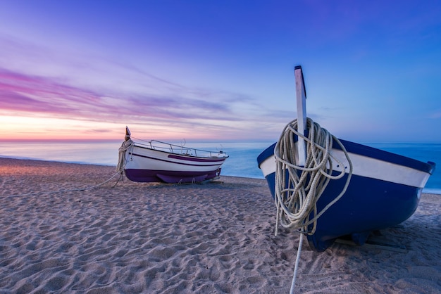 Barca da pesca sulla spiaggia sabbiosa all'alba nostalgica