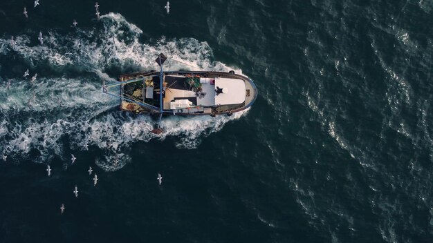 Barca del peschereccio che galleggia nella vista aerea del mare blu dal drone