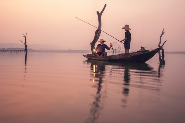 Barca del tramonto della rete del pescatore della siluetta